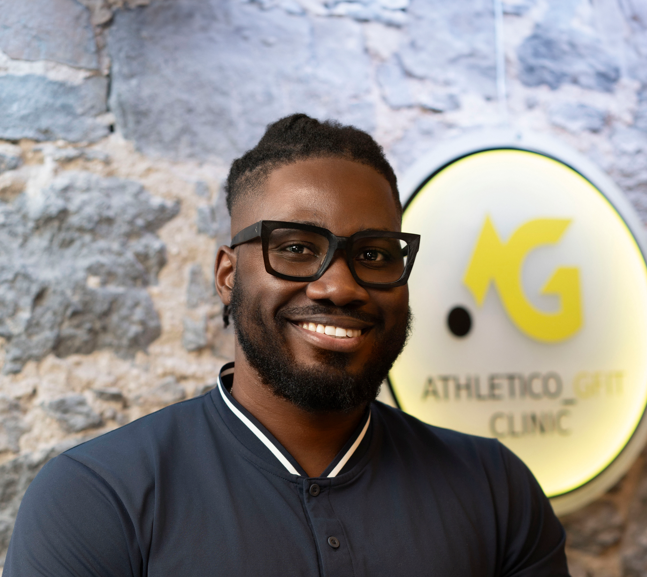 Portrait of Parfait Fiogbe in front of the Athletico GFIT sign