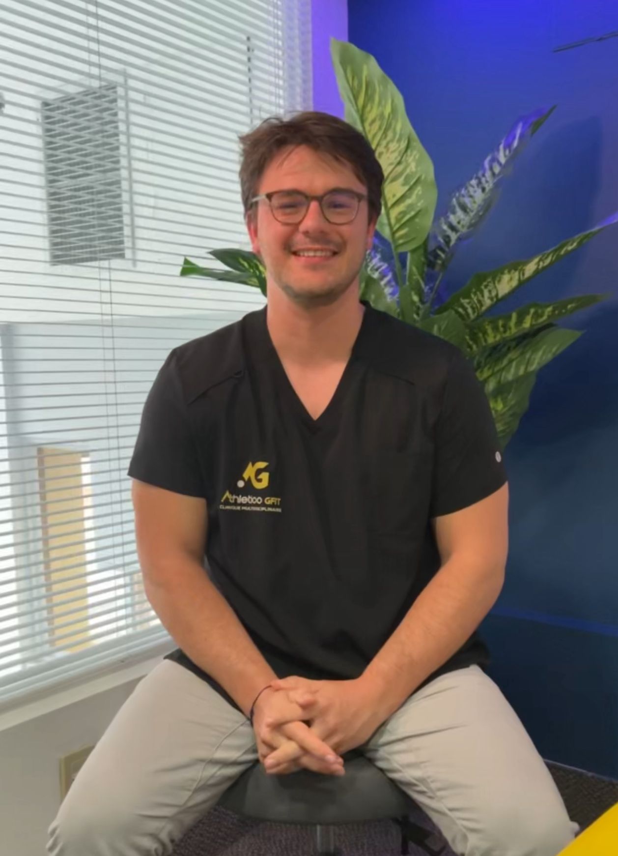 Portrait de Stanislas Martinez Carnicier assis à la clinique en uniforme Athletico GFIT